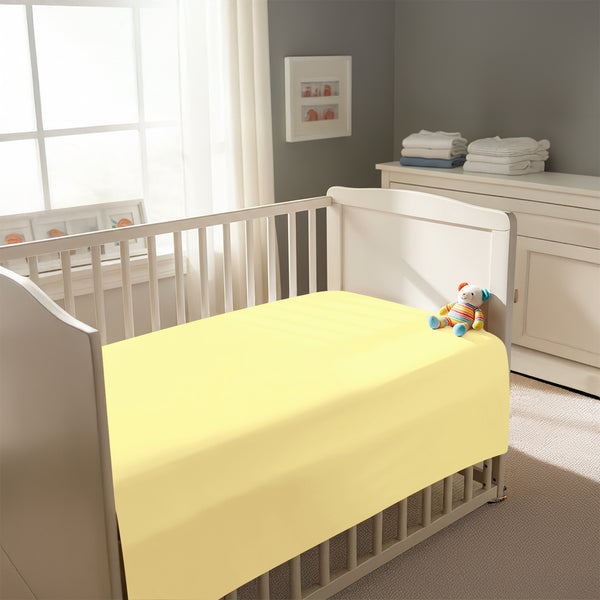 Peaceful nursery scene showing a crib with a mellow yellow cotton crib flat sheet 120×150 cm