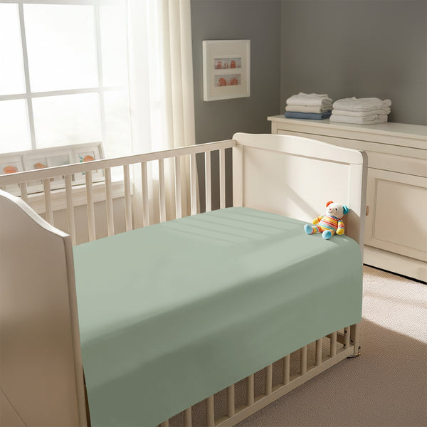 Peaceful nursery scene showing a crib with a sea foam cotton crib flat sheet 70×100 cm