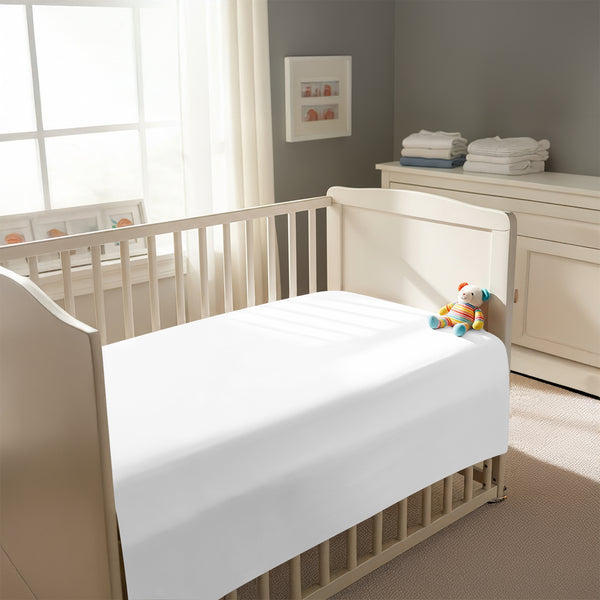 Peaceful nursery scene showing a crib with a white cotton crib flat sheet 70×100 cm