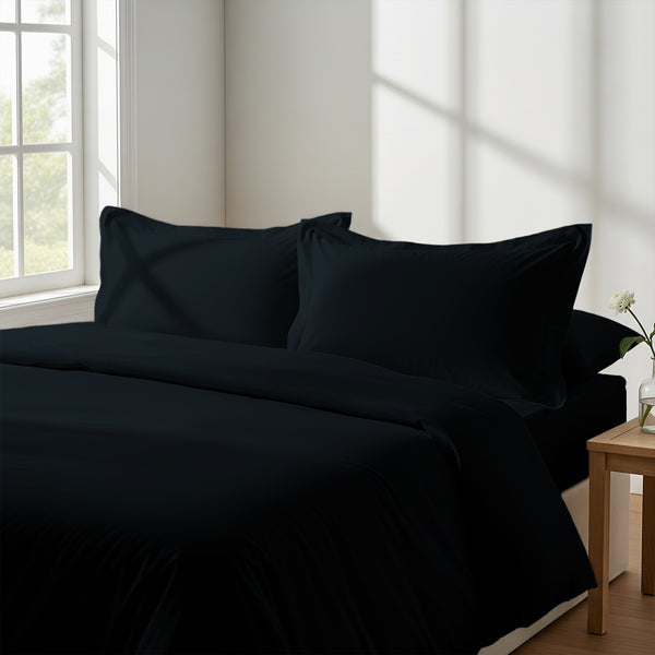 Bedroom with 3 piece 600 thread count black double duvet cover and pillowcases on the bed