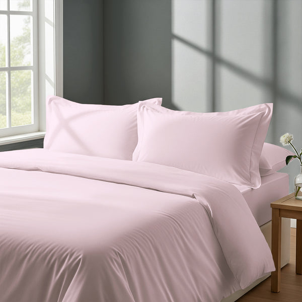 Bedroom with bed dressed in royal 1000 thread count light pink double duvet cover with Oxford pillowcases