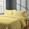 Bedroom with bed dressed in royal 1000 thread count mellow yellow king duvet cover with Oxford pillowcases