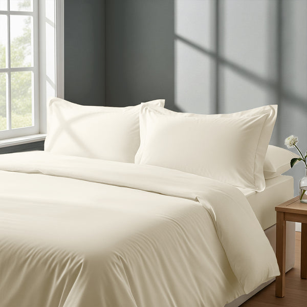 Bedroom with bed dressed in royal 1000 thread count ivory king duvet cover with Oxford pillowcases