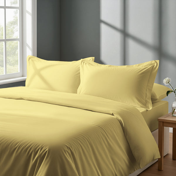 Bed in bedroom dressed with luxurious Mellow Yellow king 800 thread count duvet cover 3 piece and pillowcases