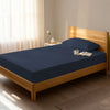 Bed in a bedroom dressed with 400 thread count dark blue eu single cotton fitted sheet