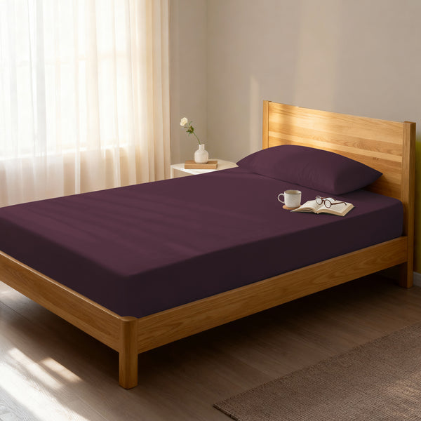Bed in bedroom dressed with luxurious 1000 thread count dark purple Single