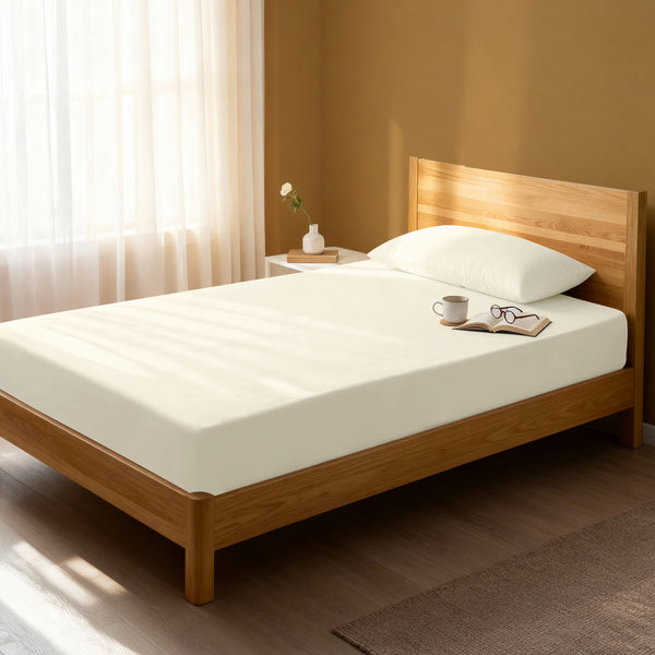 Bed in a bedroom dressed with 400 thread count ivory single cotton fitted sheet