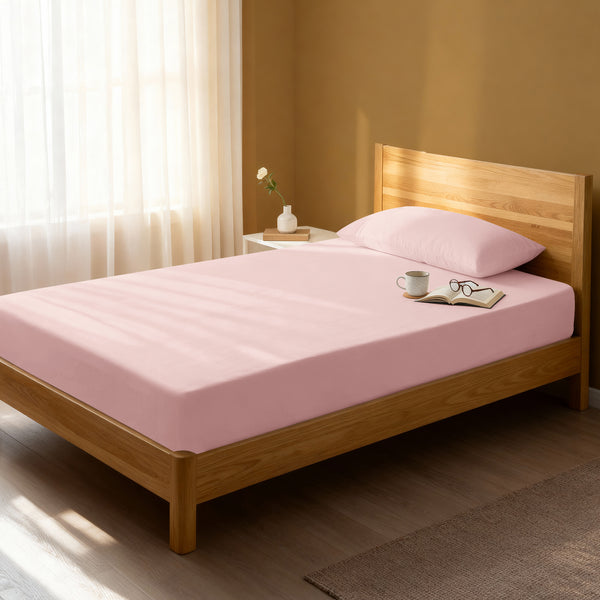 Bed in a bedroom dressed with 400 thread count light pink eu single cotton fitted sheet