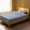 Bed in a bedroom dressed with 400 thread count smart checks navy small single cotton fitted sheet