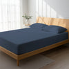 Bed in bedroom dressed with luxurious 1000 thread count dark blue Double