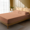 Bed in a bedroom dressed with 400 thread count Dusty Coral small double cotton fitted sheet