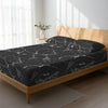 Bed in a bedroom dressed with 400 thread count Marble Black Emperor cotton fitted sheet
