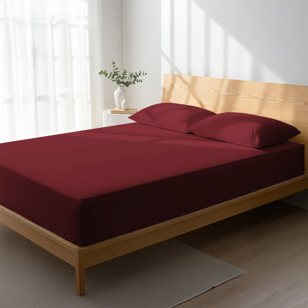 Bed in a bedroom dressed with 400 thread count Rio Red emperor cotton fitted sheet
