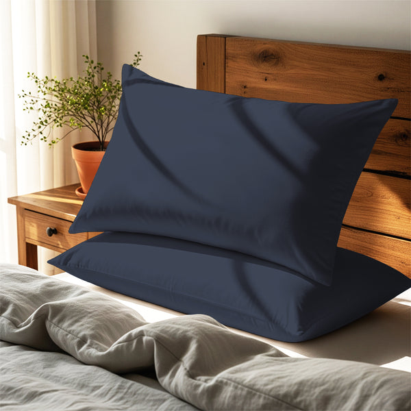 Dark blue housewife pillowcases cotton percale on pillows on bed in bedroom