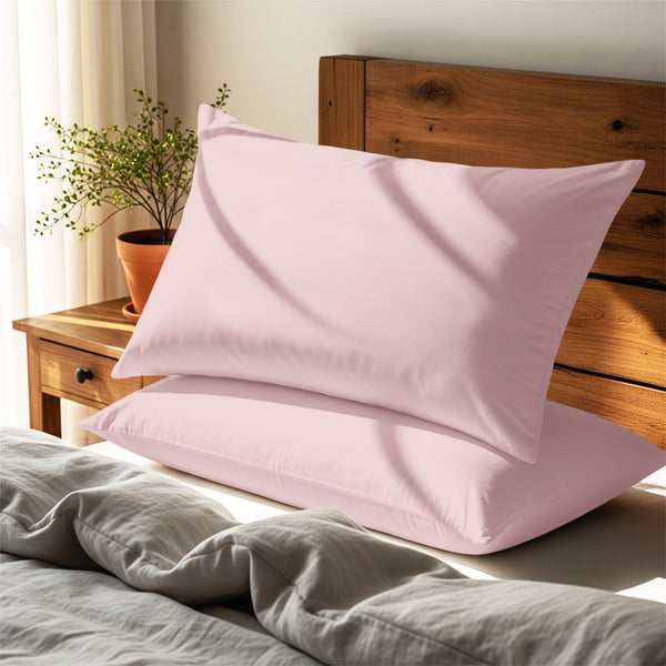Light pink housewife pillowcases cotton percale on pillows on bed in bedroom