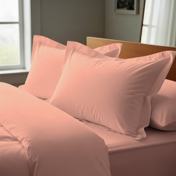 coral pink oxford standard pillowcases premium 400 thread count on pillows on bed in bedroom