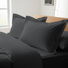 Dark grey oxford standard pillowcases deluxe 600 thread count on pillows on bed in bedroom