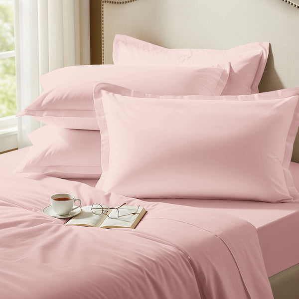 Light pink oxford standard pillowcases premium 400 thread count on pillows on bed in bedroom