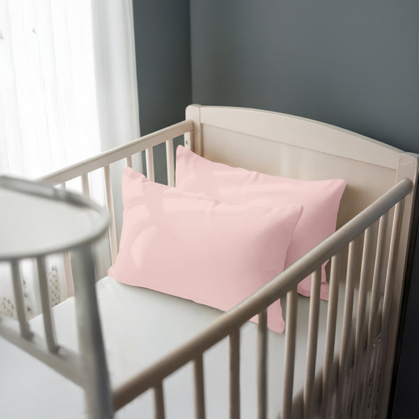Toddler bed with light pink 33 x 46 cm cotton pillowcase on the pillow